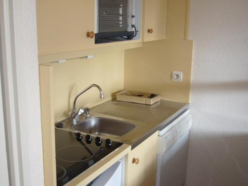 uma pequena cozinha com um lavatório e um micro-ondas em Fontaines Blanches 320 em Avoriaz