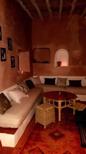 a living room with a couch and a table at Tigmi Hamid Découverte des traditions et de la culture berbère in Aït Ben Haddou