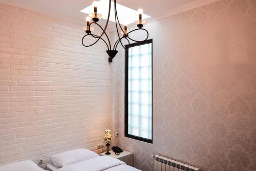 a bedroom with a white brick wall and a mirror at Eleon Boutique Hotel in Tbilisi City