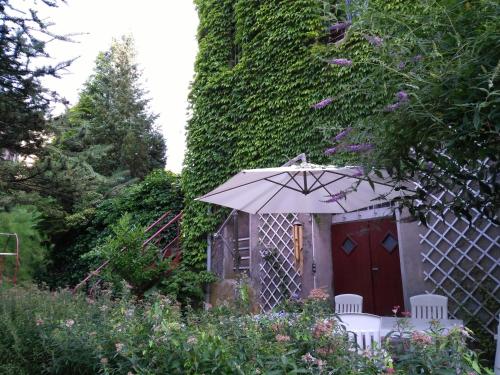 a table and chairs with an umbrella in a garden at Villa Giselle in Hayange