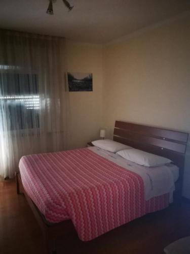 a bedroom with a large bed with a pink blanket at l'igloo b&b in Sedico