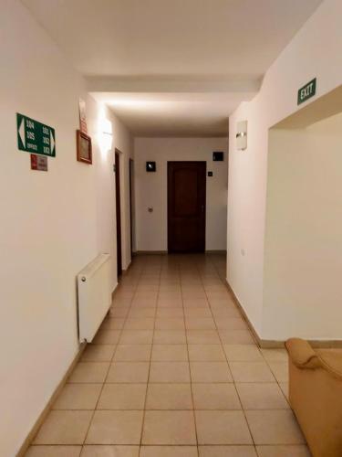 an empty hallway with a door and a tiled floor at Pensiunea Agroturistică Piscul Soarelui in Cîmpulung