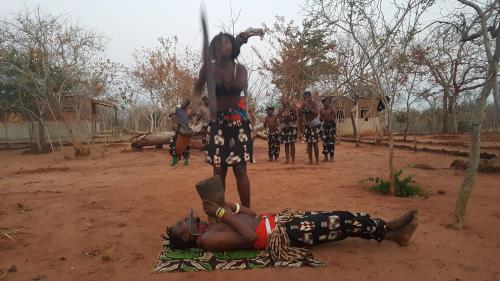 a man laying on the ground in the dirt with a person at Mukuni Villas in Livingstone