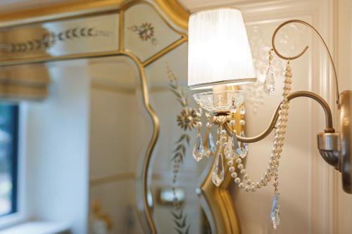 lampa przymocowana do ściany z lustrem w obiekcie Villa Luttwitz w Baden-Baden