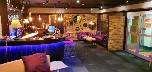 a bar in a restaurant with purple stools at Samantta Hotel & Restaurant in Haukipudas