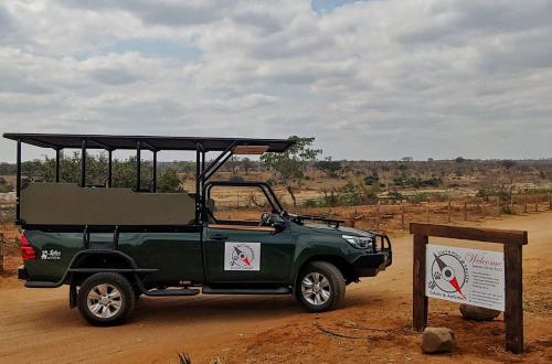a green jeep parked in the desert with a sign at The South Post @ Kruger in Marloth Park
