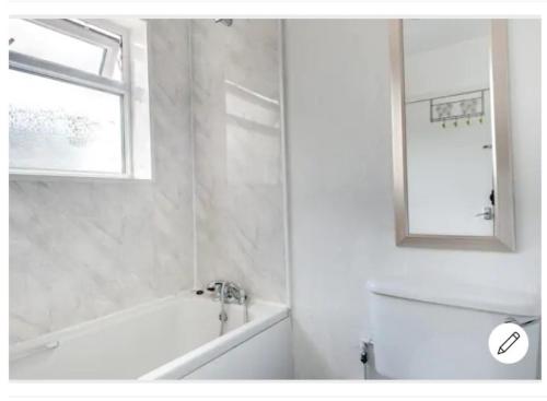 a bathroom with a tub and a sink and a mirror at Your Nottingham Vacation, Business Apart, Parking in Nottingham