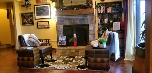 a living room with two chairs and a fireplace at Chateau du Pikes Peak, a Tuscany Retreat in Colorado Springs
