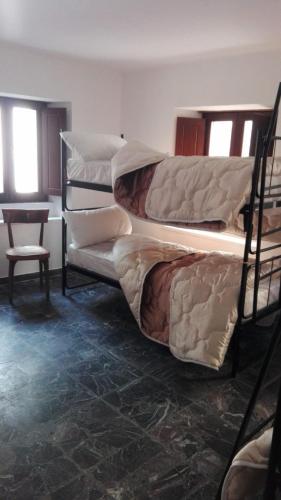 two bunk beds in a room with a table and a chair at PHOENIX HOSTEL in Valprato Soana