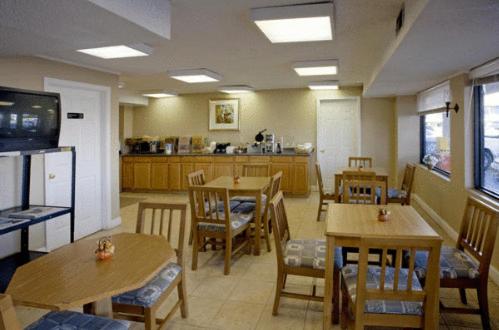 a restaurant with tables and chairs and a kitchen at Americas Best Value Inn & Suites in Murfreesboro in Murfreesboro