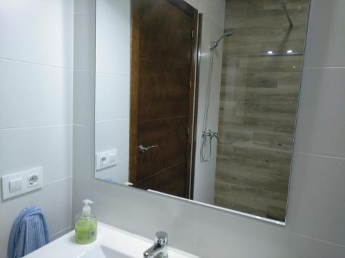 a bathroom with a sink and a shower with a mirror at Chalet en Roche in Conil de la Frontera