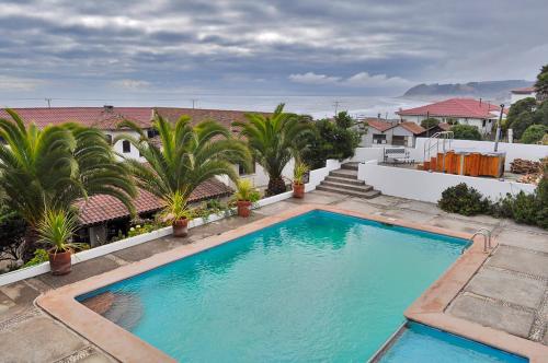 una piscina en un patio con palmeras en Hosteria Iloca en Iloca