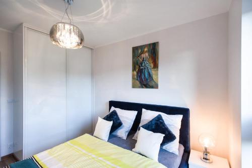斯塞新的住宿－Apartament T.LOVE NOVA 2，卧室配有一张床,墙上挂有绘画作品