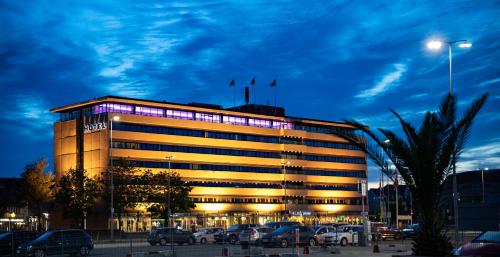un edificio con coches estacionados en un estacionamiento en Hotel Jutlandia, en Frederikshavn