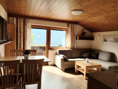 ein Wohnzimmer mit einem Sofa und einem Tisch in der Unterkunft Ferienwohnung Bernsteiner in Iselsberg