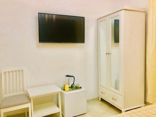 Pokój z białą szafką i telewizorem na ścianie w obiekcie ABID'S PALACE IN TERMINI w Rzymie