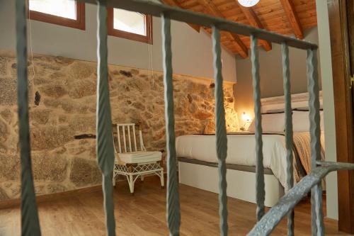 a bedroom with a bed in a stone wall at A Cucada in Sabariz