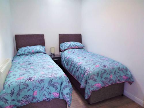 two beds sitting next to each other in a bedroom at 67c The Mews in Newport