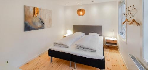 a bedroom with a bed with white sheets at Harbour View in Sønderborg
