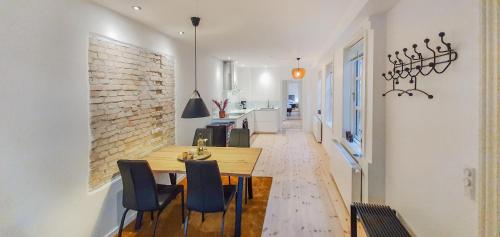 a dining room with a wooden table and chairs at Harbour View in Sønderborg