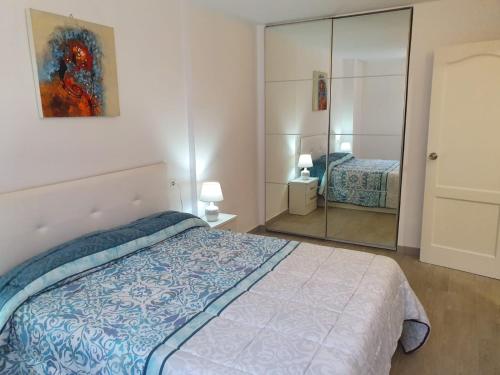 une chambre avec un lit et un miroir dans l'établissement Apartamento Torres del Sol, à Arona