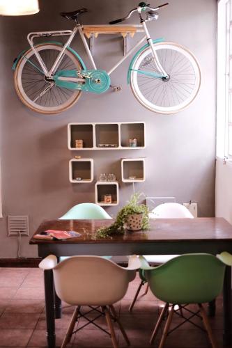 a bike hanging from a wall above a dining room table at Leónidas Design Loft in Mendoza