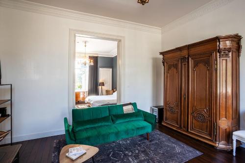 a living room with a green couch and a bedroom at OsTi in Ghent