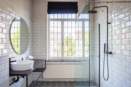 a bathroom with a sink and a shower and a mirror at OsTi in Ghent