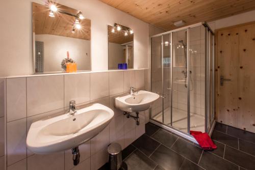 ein Bad mit 2 Waschbecken und einer Dusche in der Unterkunft Haus Silberberg in Bartholomäberg