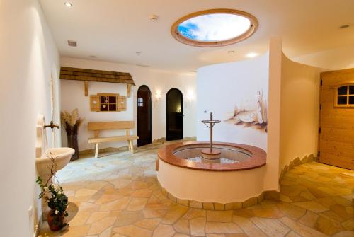 Un baño con bañera en medio de una habitación. en Apartments Sunela, en Selva di Val Gardena