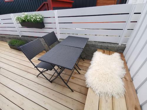 a patio with two chairs and a table and a rug at City Center Apartment in Tórshavn