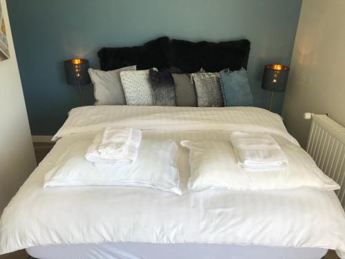 1 cama blanca grande con 2 toallas plegables. en Dalabyggd Cottages - Romantic stay by the Secret Lagoon, en Fludir