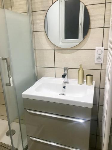 une salle de bain avec un lavabo blanc et un miroir dans l'établissement Le Secret de Louise, à Épernay