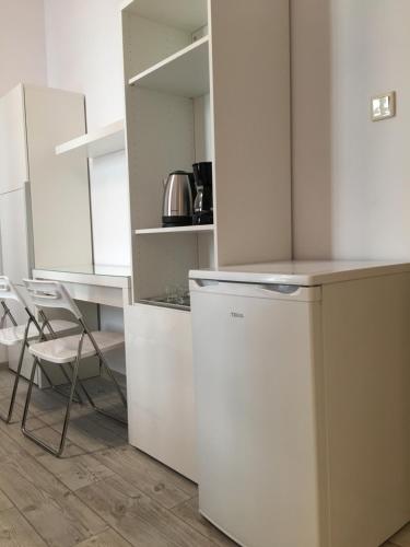 a kitchen with a white refrigerator and a table and chairs at Orion in Krakow
