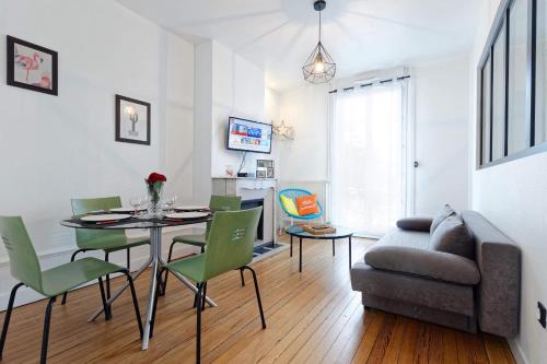 un salon avec une table, des chaises et un canapé dans l'établissement L’atelier de Loane, au Havre