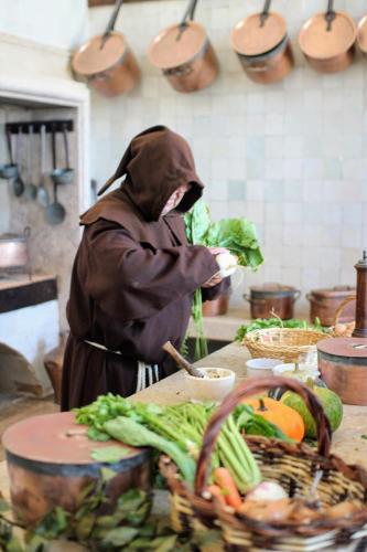 a person in a kitchen preparing food on a counter at Vila Mafra - Grill Terrace in Mafra