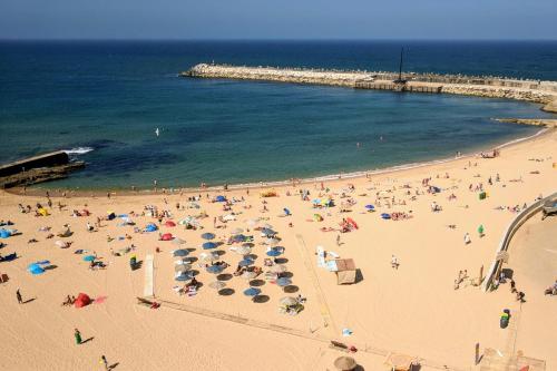 a group of people on a beach with umbrellas at Vila Mafra - Grill Terrace in Mafra