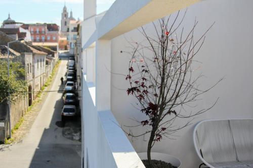 a balcony with a tree on the side of a building at Vila Mafra - Grill Terrace in Mafra