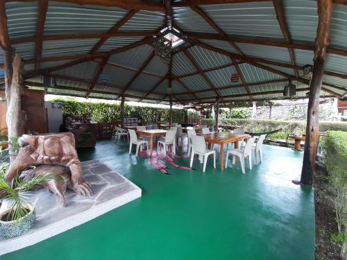 a patio with tables and chairs under a roof at Suymar Ecolodge Galapagos in Puerto Ayora