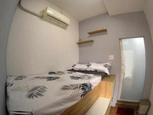 1 dormitorio con 1 cama con edredón blanco y negro en Te House, en Ho Chi Minh