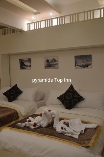 a hotel room with two beds with towels on them at Pyramids Top Inn in Cairo