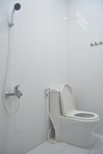 a white bathroom with a toilet and a shower at Bausasran52 in Yogyakarta
