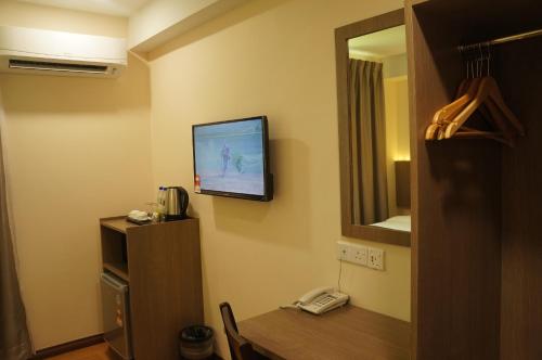 a room with a television on a wall with a table at LABUAN JATI HOTEL in Labuan