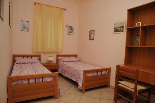 1 dormitorio con 2 camas y escritorio en Villa Grazia, en Marina di Noto