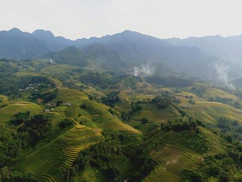 an aerial view of a green hillside with mountains at SaPa Farmer House in Sa Pa