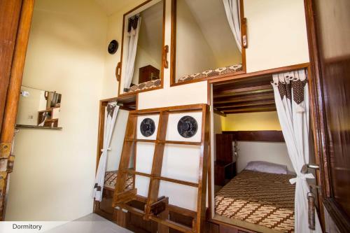 een kamer met een stapelbed en een spiegel bij Duta Guest House in Yogyakarta