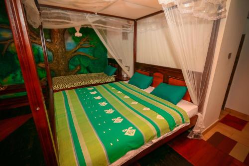 a bedroom with a bed with a tree mural at Happy Horizon Home Stay in Ella