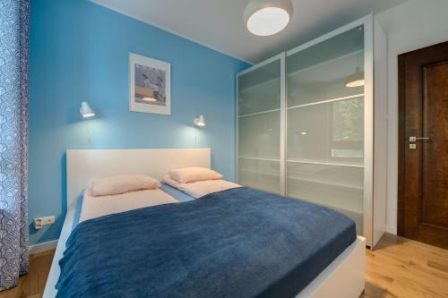 1 dormitorio con paredes azules y 1 cama con 2 almohadas en Aquarius & FREE PARKING, en Sopot