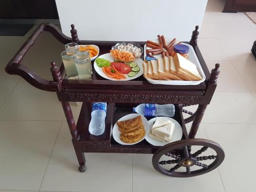 a tray of food on a cart with plates of food at VIVAS Residencies Luxury Apartments in Colombo