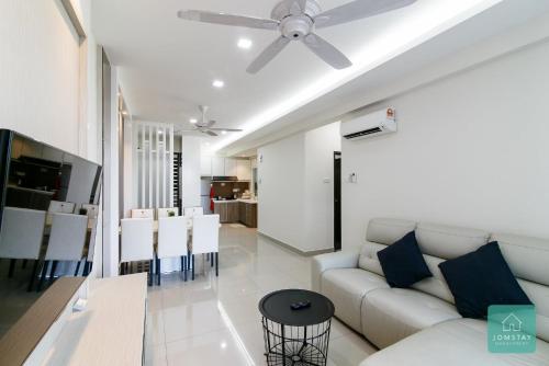 a living room with a white couch and a ceiling fan at JOMSTAY Majestic Ipoh Suites in Ipoh